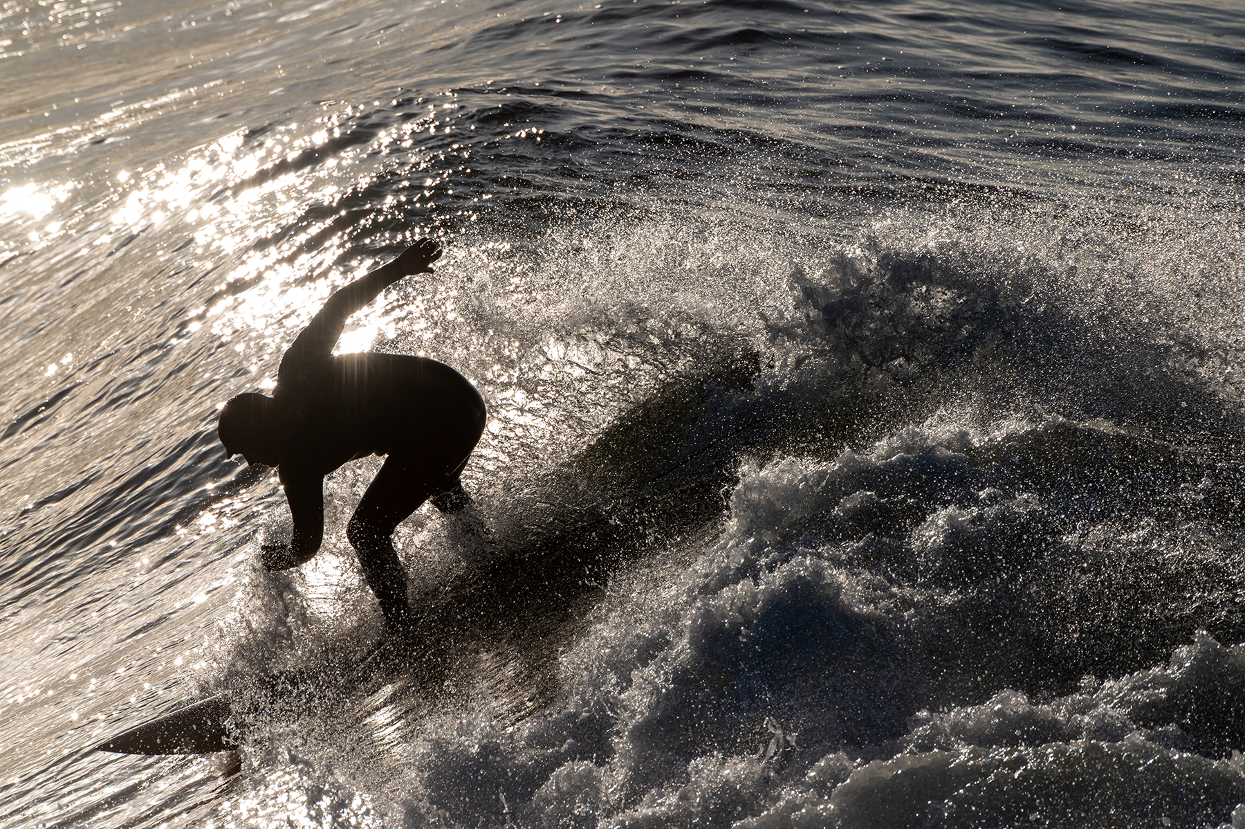 black and white image of a surfer on the downhill slope of a wave