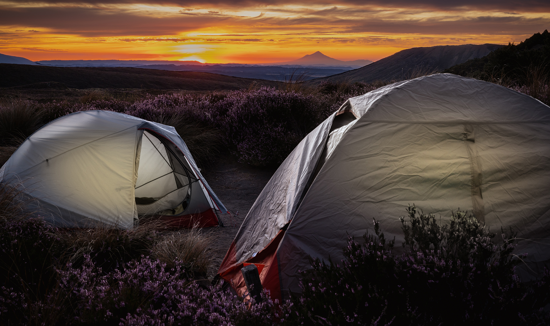 evening shot of tents in Tongariro National Park, New Zealand, with Mt Taranaki in background