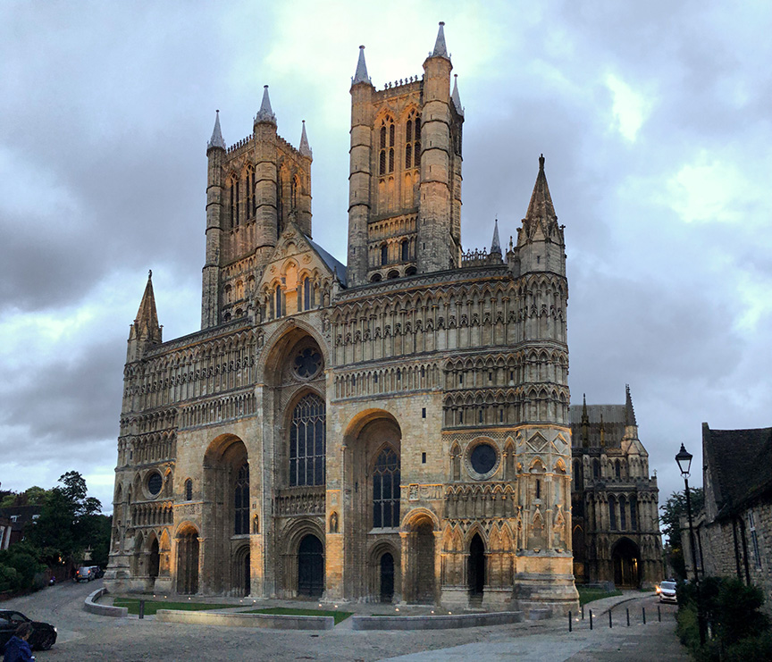 West façade of Lincoln Cathedral in evening and rain clouds.