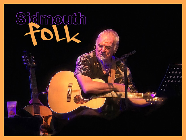 Poster of singer/songwriter Ralph McTell on stage, on a break between songs. The text reads "Sidmouth Folk."