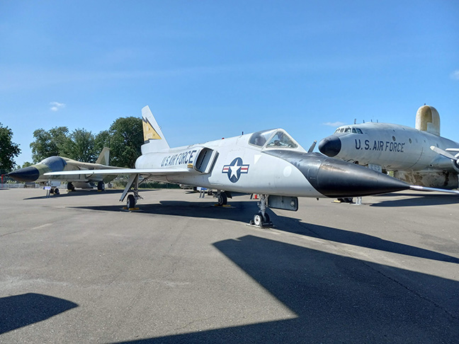 F106 Delta Dart fighter and other military aircraft parked together at the Aerospace Museum of California.
