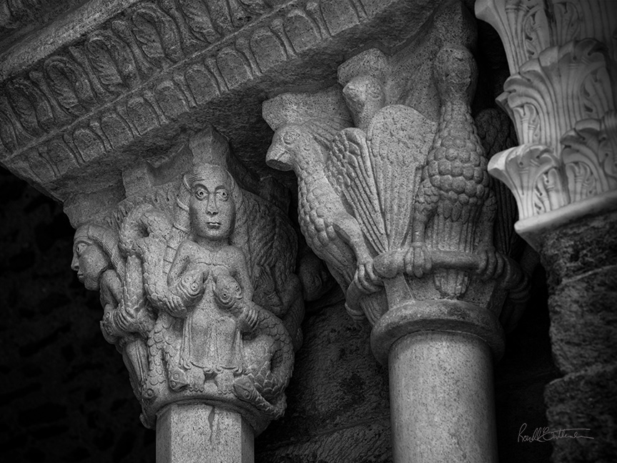 Medieval column capitals, showing winged creatures and serpents suckled by a woman, northern Italy.